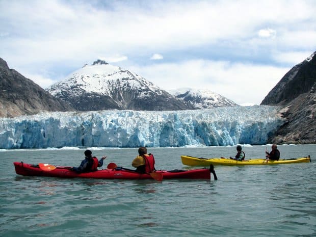 A group of people kayaking near a glacier in Alaska.