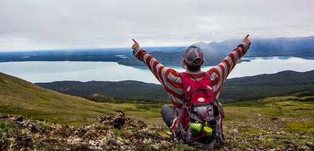 Guest at  Skilak lake backcountry lodge at viewpoint overlooking waterway in Alaska. 