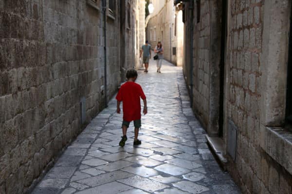 Child walking down marble alleyway in Dubrovnik Croatia.
