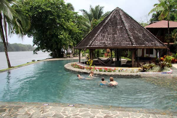 Young traveler children playing in the pool of a Costa Rican lodge next to the ocean.