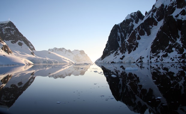 Sunset in a calm channel while cruising by small ship in Antarctica.