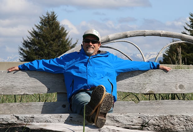 AdventureSmith founder Todd Smith relaxing on a wooden bench in Gustavus Alaska.