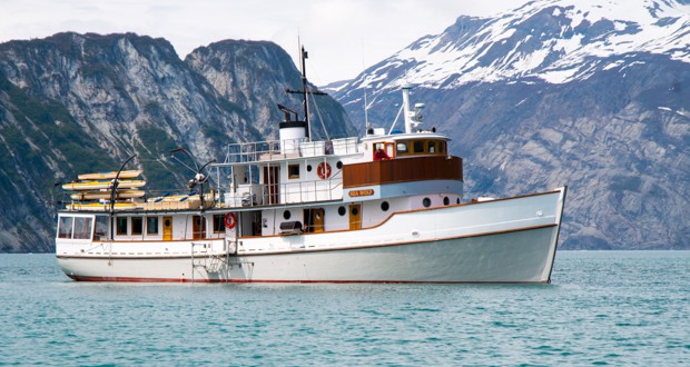 Small ship Sea Wolf cruise with mountains in the background sailing in Alaska.