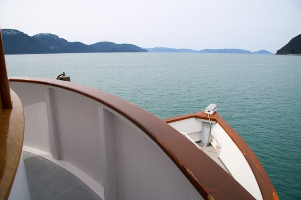 View from a deck looking down onto the bow of a small ship cruise in Alaska.