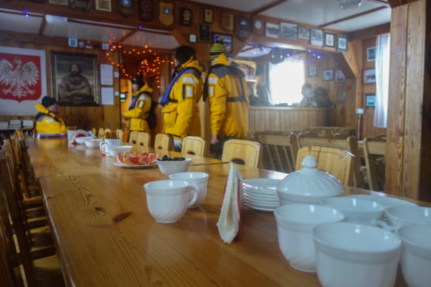 Guests from a small ship cruise have coffee inside the polish research station in Antarctica.