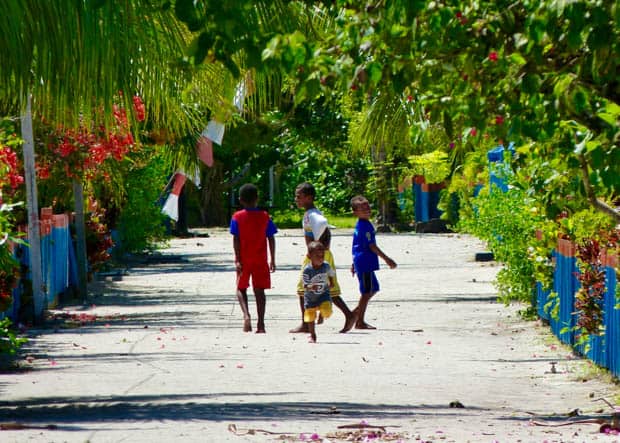 Local children skipping through the street in Indonesia.