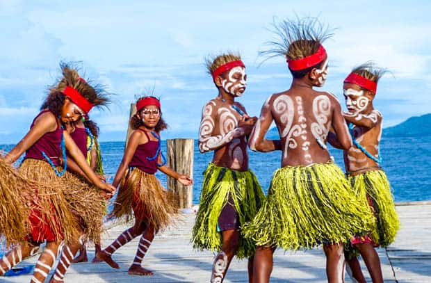 Local children doing a traditional dance on the dock in Indonesia.