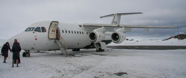 People getting on a plane on the snow in Antarctica.