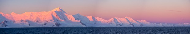 Sunset turning the mountains pink in Antarctica seen from a small ship cruise.