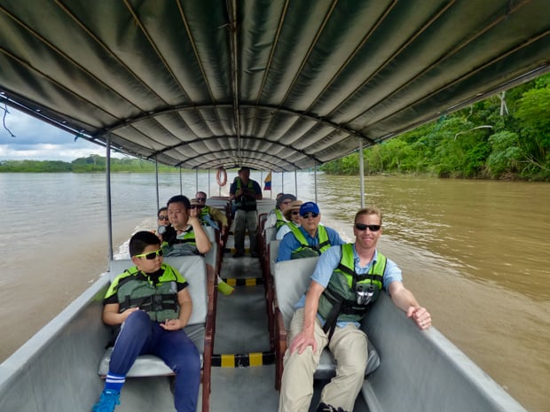A group of people on a motorized canoe heading out for a land excursion.