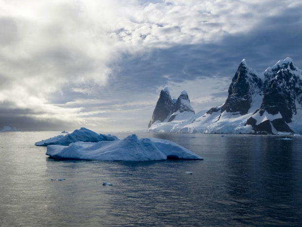 Iceberg and jagged snowy peaks of Antarctica seen from a small ship cruise.