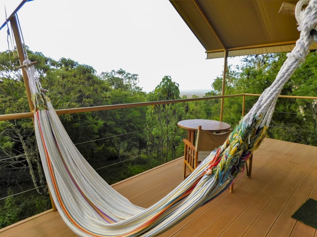 Outside deck with a hamock, table and chairs overlooking lush forest in the Galapagos on a land tour.