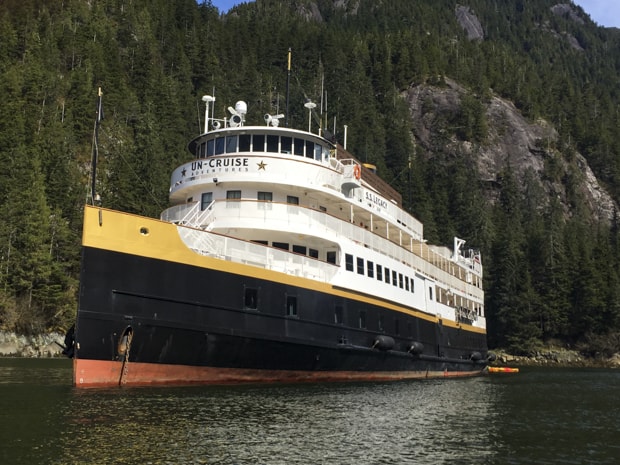 Small ship S.S. Legacy close to shore in Alaska.