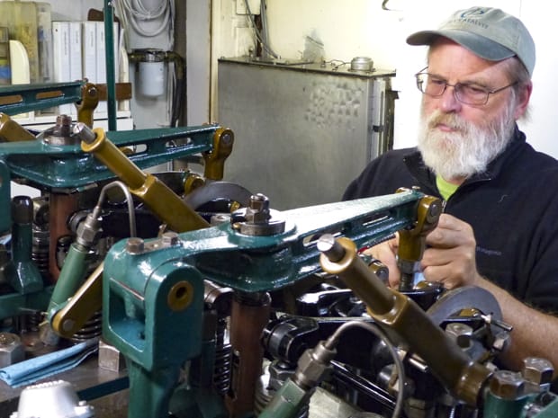 Westward small ship cruise captain works on the boat engine.