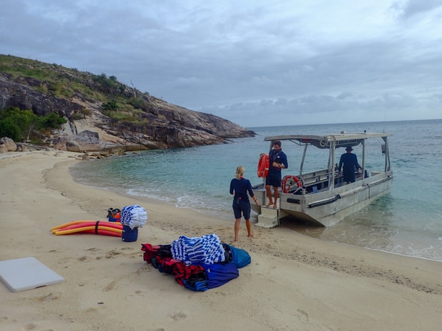 A metal tender dropping of supplies for a day at the beach for small ship cruisers with towels, swim noodles and a table.
