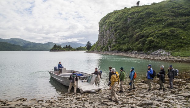 Guests from small ship cruise get on a skiff excursion from the shore in Alaska.