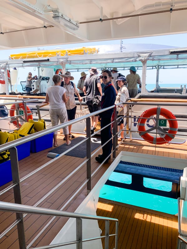 From inside the stern of the Coral Adventurer guests get aboard the smaller expedition vessel that takes them ashore. Metal handrains and a wodden walk way leads to the vessel