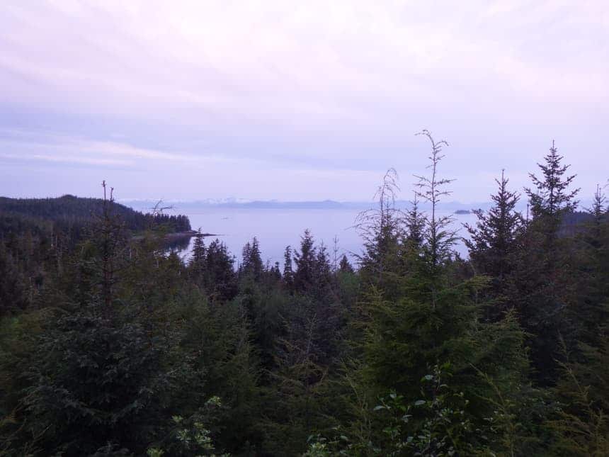 A purple sunset tints the sky above hobart bay in Alaska, a short hike to the top to overlook the green forest that surrounds the bay.