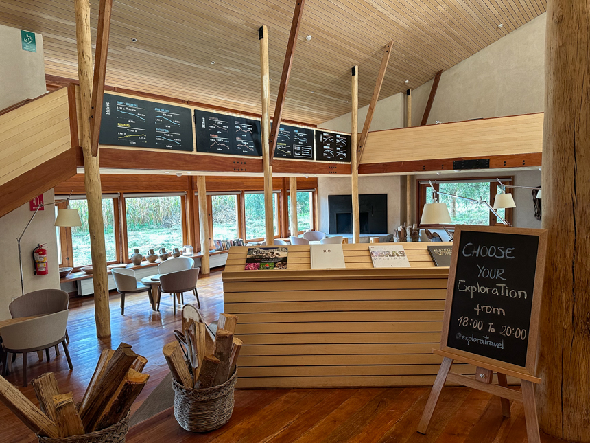 Briefing area at Explora Sacred Valley lodge. Light wood beams, tables, windows and black chalk board menus with activities