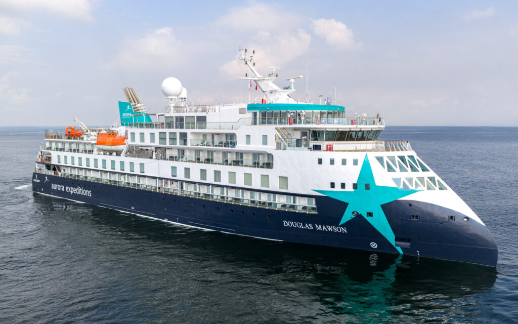 Douglas Mawson expedition ship in polar sea with pointed bow, glass atrium, 8 decks, gray, white & green paint.