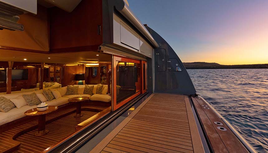 The back deck of the luxury Galapagos yacht Aqua Mare showing the swim deck and open doors to a large couch lounge