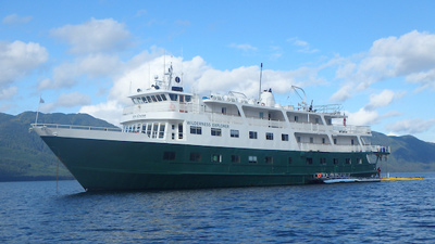 UnCruise Alasksa reviews 74-guest Wilderness Explorer with painted green hull and white upper decks.