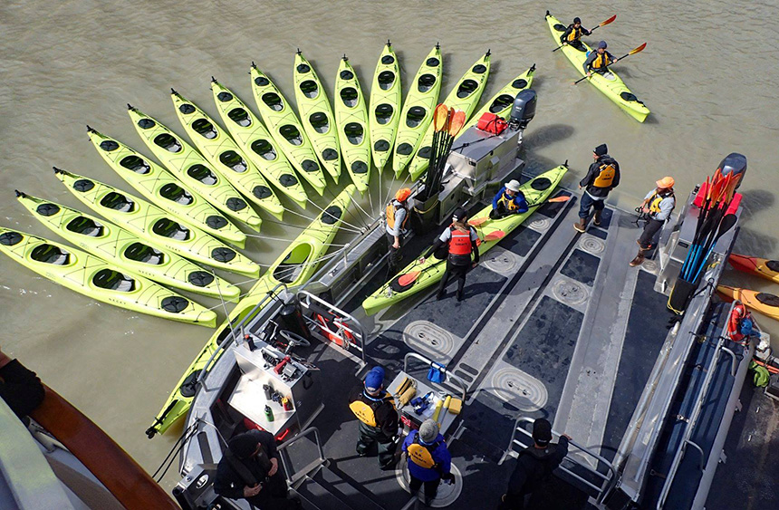 15 lime green double kayaks are tied to
a custom aluminum platform called the Sea Dragon used for kayak activity aboard UnCruise trips.
