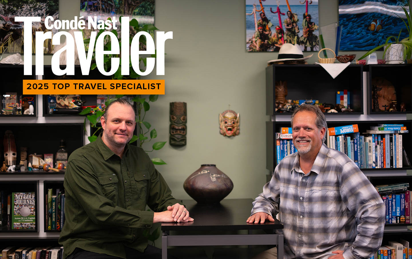 Travel specialists sitting at a table next to bookshelves stacked with books and items brought back from travels