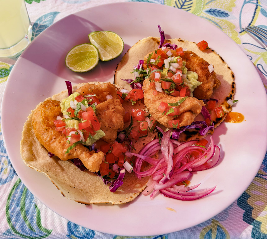 fresh fish tacos with salsa and onion served on a Lindblad Baja cruise with cut limes on the side