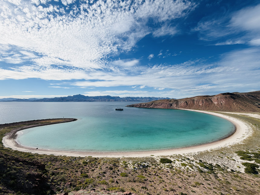 The Lindblad Venture ship seen at anchor in a remote beach lined bay in Baja California that is the shape of a near perfect circle