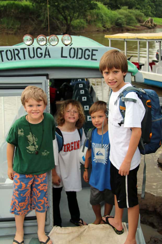 Group of young travelers embarking on a river boat in Costa Rica.