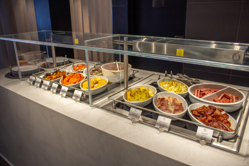 Buffet breakfast in Sila Restaurant aboard Le Commandant Charcot with white serving plates of foodunder warming trays.