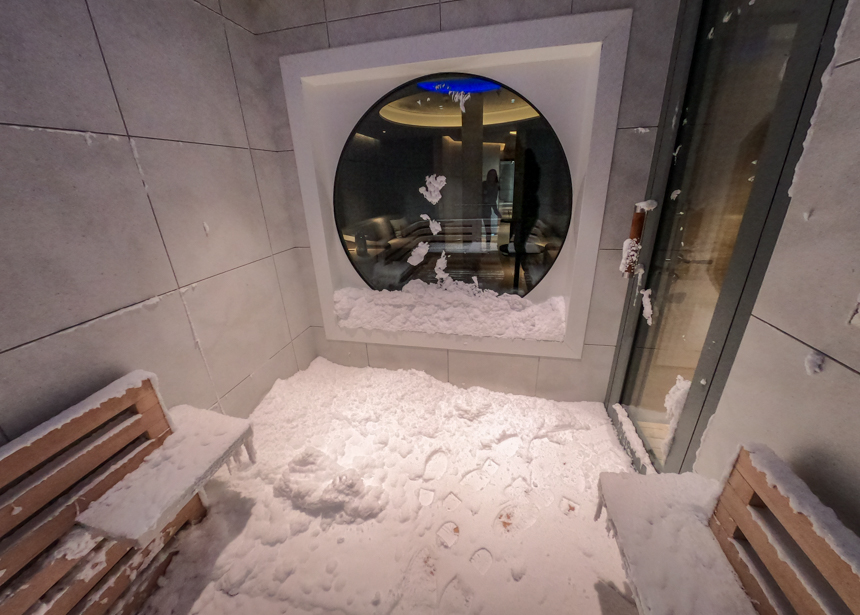 Snow Room aboard Le Commandant Charcot, wooden benches and circular window covered in white snow.