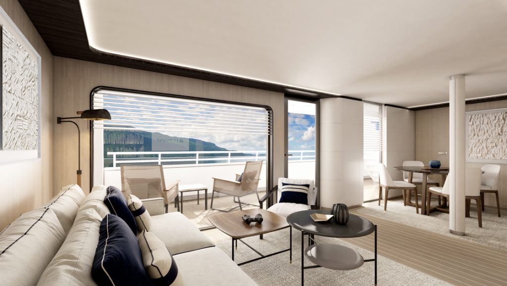 Cabin living room on Le Ponant ship with small beige couch, coffee tables, dining table & 4 chairs & glass door to balcony.