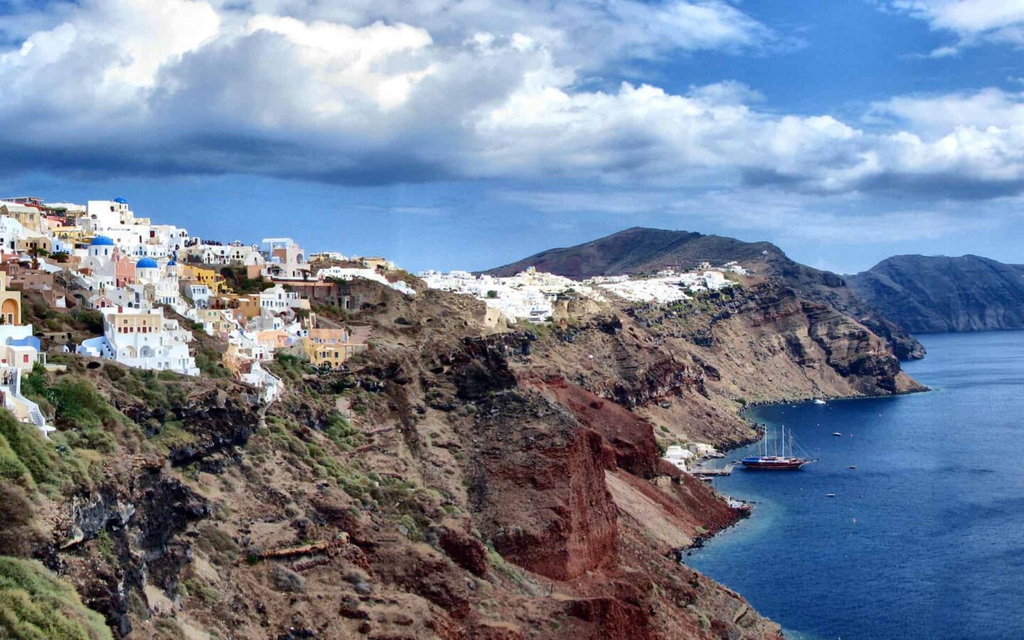 looking down the greek coast with a small cliffside village on a sunny day