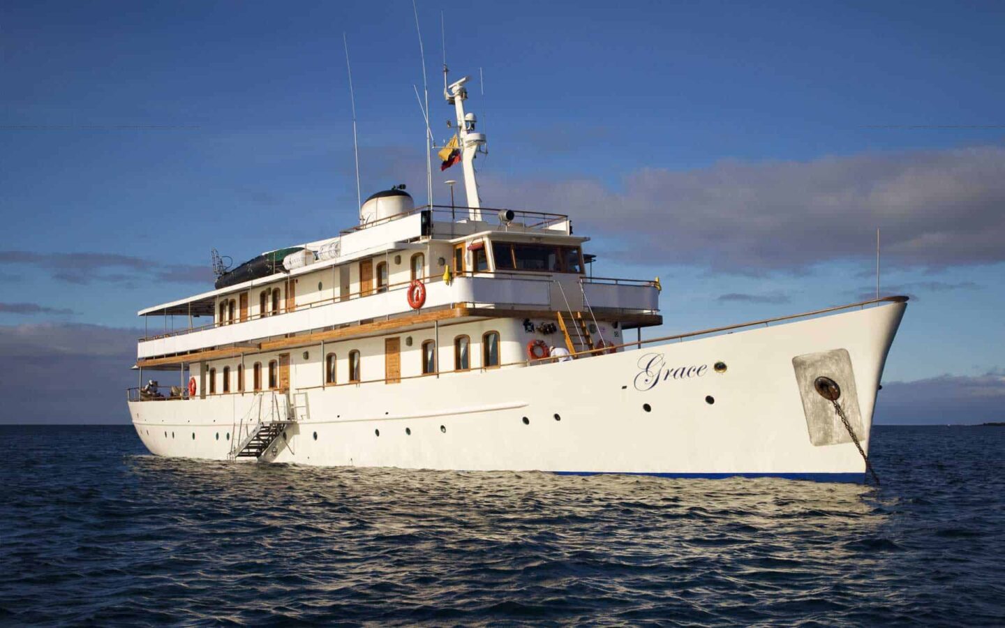 Galapagos small ship grace, sailing with her white hull, wood accents, portholes and a large viewing deck. This ship has three decks.
