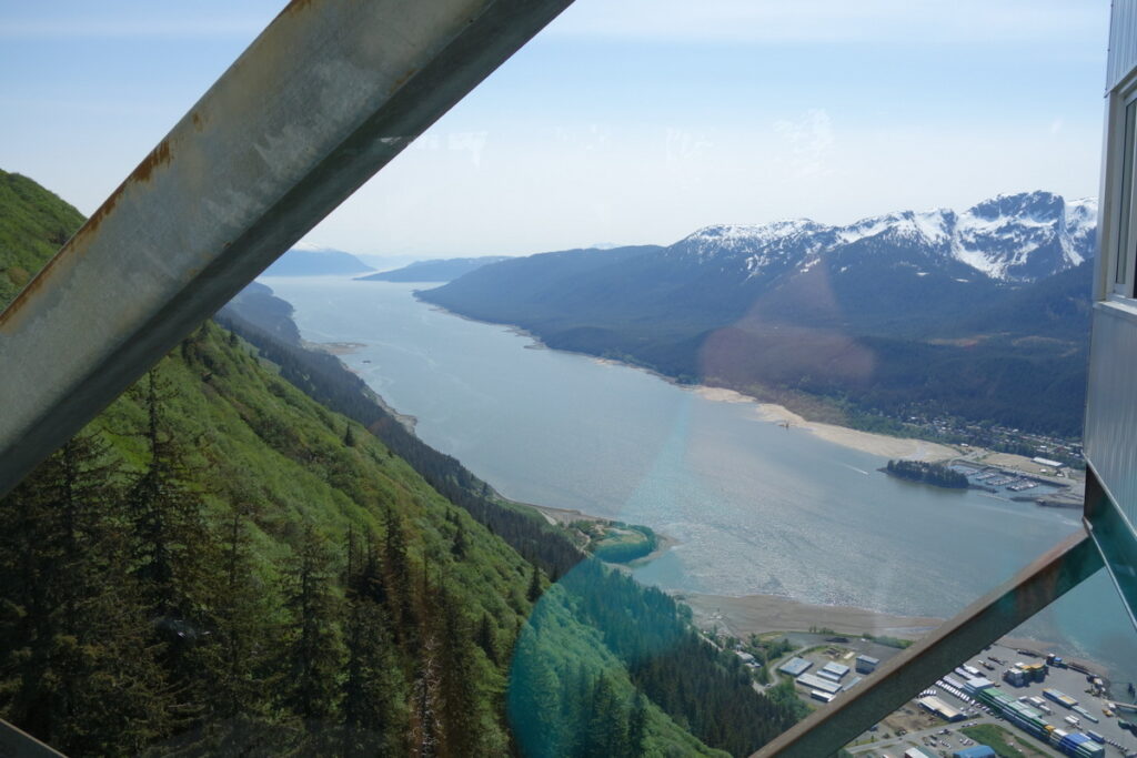 View from inside the tram in Juneau's Mount Roberts showing the long fjord and snow capped mountains