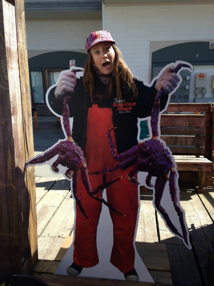 A woman in a hat poses at Tracy's Crab Shack's photo display looking like you are a crab fisherman