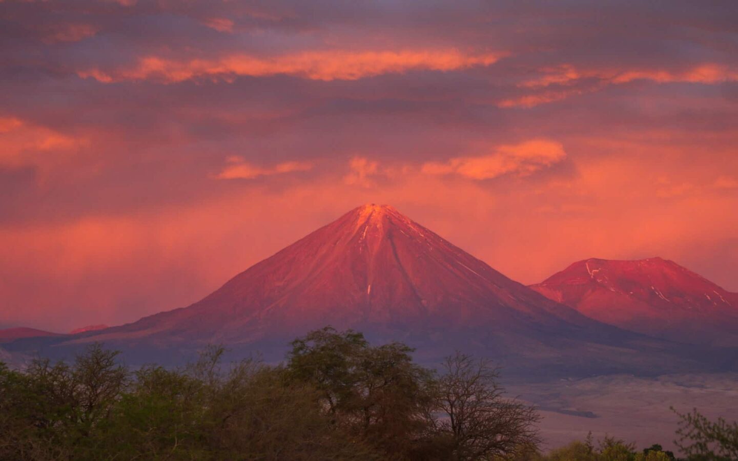 A sunset on a volcano making the sky and mountains pink on the Atacama Desert.