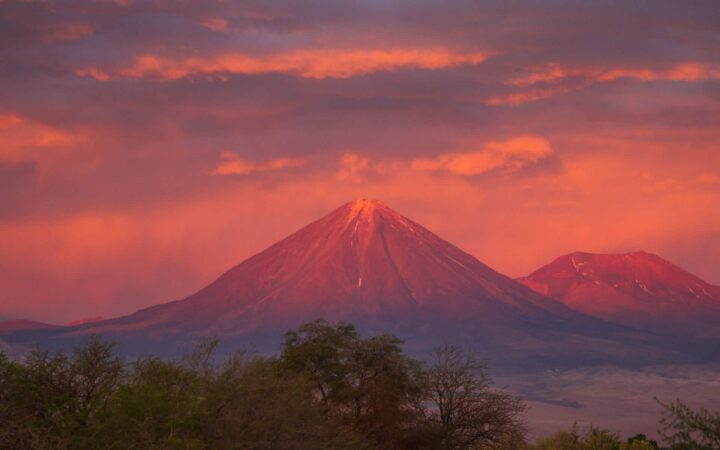 A sunset on a volcano making the sky and mountains pink on the Atacama Desert.