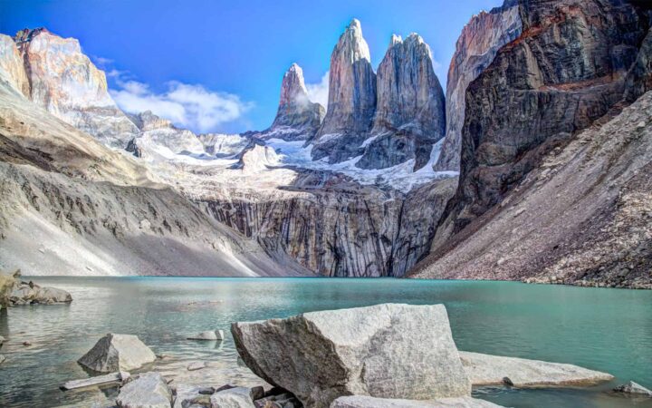 looking across a turquoise lake at jagged mountains of patagonia on a land tour