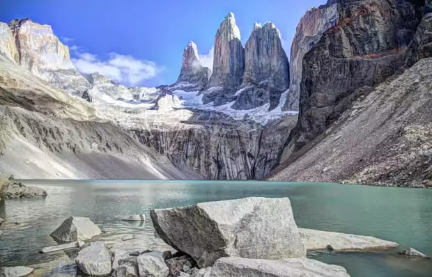 the three towers of Patagonia's Torres del Paine seen from the glacial green lake beneath them