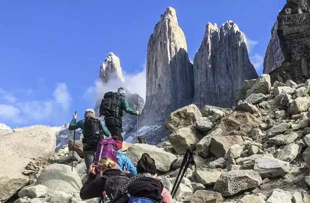 Hikers climbing the final rocks of the moraine beneath the Towers Base of Torres del Paine