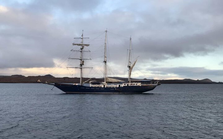 mary anne galapaos islands small ship anchored with masts showing in calm water on an overcast day