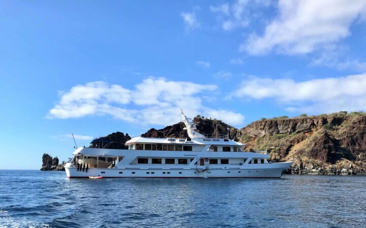 WildAid's passion small ship anchored in still water on a sunny day in the galapagos islands