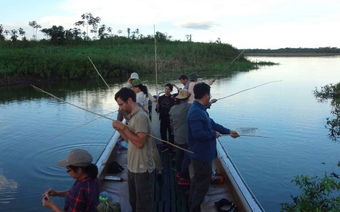 group of small ship cruise travelers fishing from a small boat on the amazon river