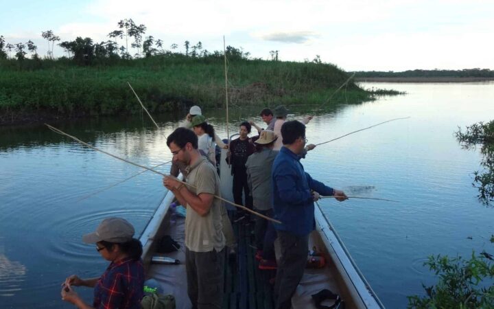 group of small ship cruise travelers fishing from a small boat on the amazon river