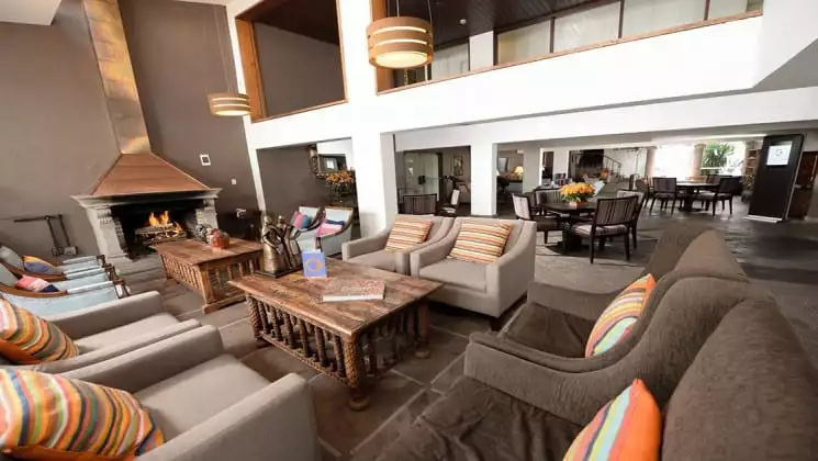 Lobby area with fireplace, multiple tables and several oversize chairs at Costa del Sol Ramada Cusco on Peru