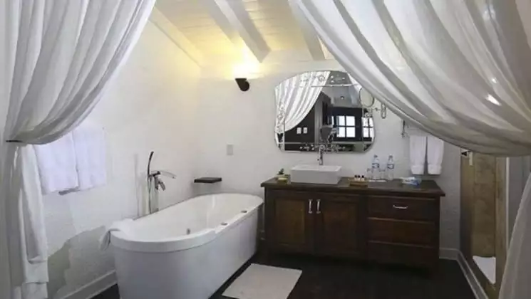 Bathroom with large soaking tub, sink and mirror at El Mercado Tunqui in Cusco, Peru