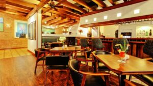 Bar with stools and nearby tables with chairs inside Hotel Bougainvillea near San Jose, Costa Rica